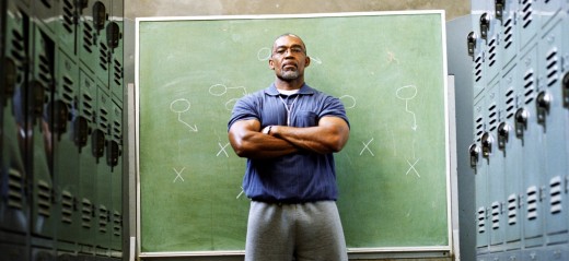 Coach in locker room, standing in front of chalkboard