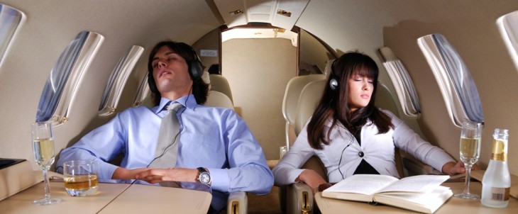 Young business couple sleeping and enjoying the flight in the small private airplane.