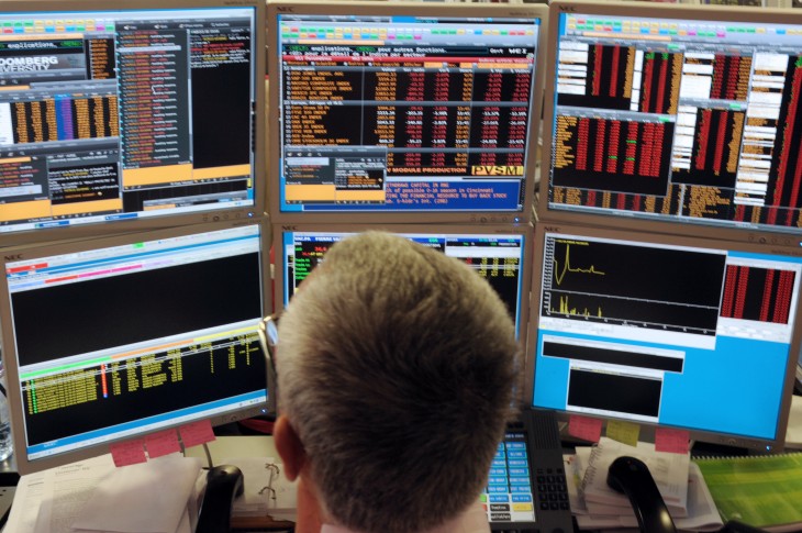A broker watches screens in an office of