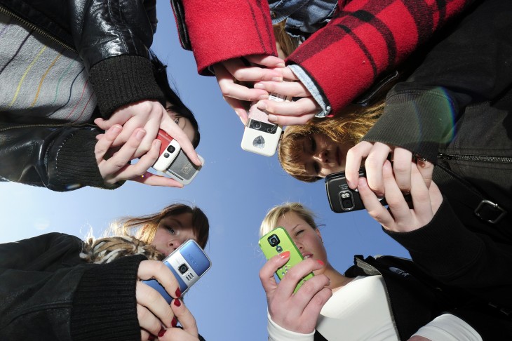 Teenagers use their mobile phones after