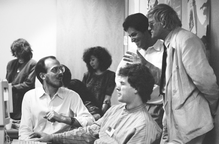 Adobe-Creative-Director-Russell-Brown-(left,-seated)-with-artists-Nicholas-Callaway-(center,-seated)-and-David-Hockney-(right,-standing)-and-other-colleagues-at-Adobe's-Art-Directors-Invitational,-1990