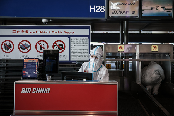 BEIJING, CHINA - FEBRUARY 21: An airport staff member in a hazmat suit works at the Beijing Capital International Airport on February 21, 2022 in Beijing, China. Officials, athletes, and media have started to leave Beijing after the closing ceremony of the Beijing 2022 Winter Olympics. (Photo by Annice Lyn/Getty Images)
