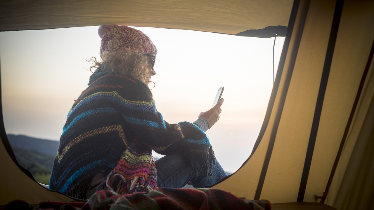 Woman in tent using smartphone