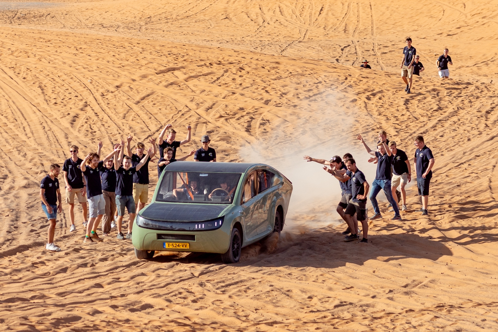 Les étudiants saluent l'arrivée d'une voiture solaire dans le désert du Sahara