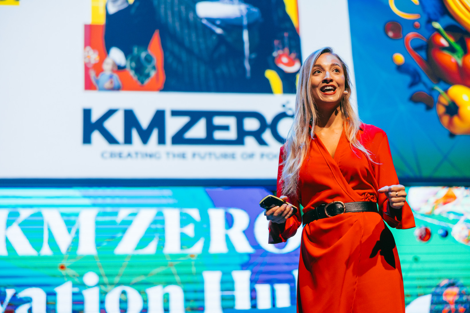 Beatriz Lozano in front of presentation screen on stage