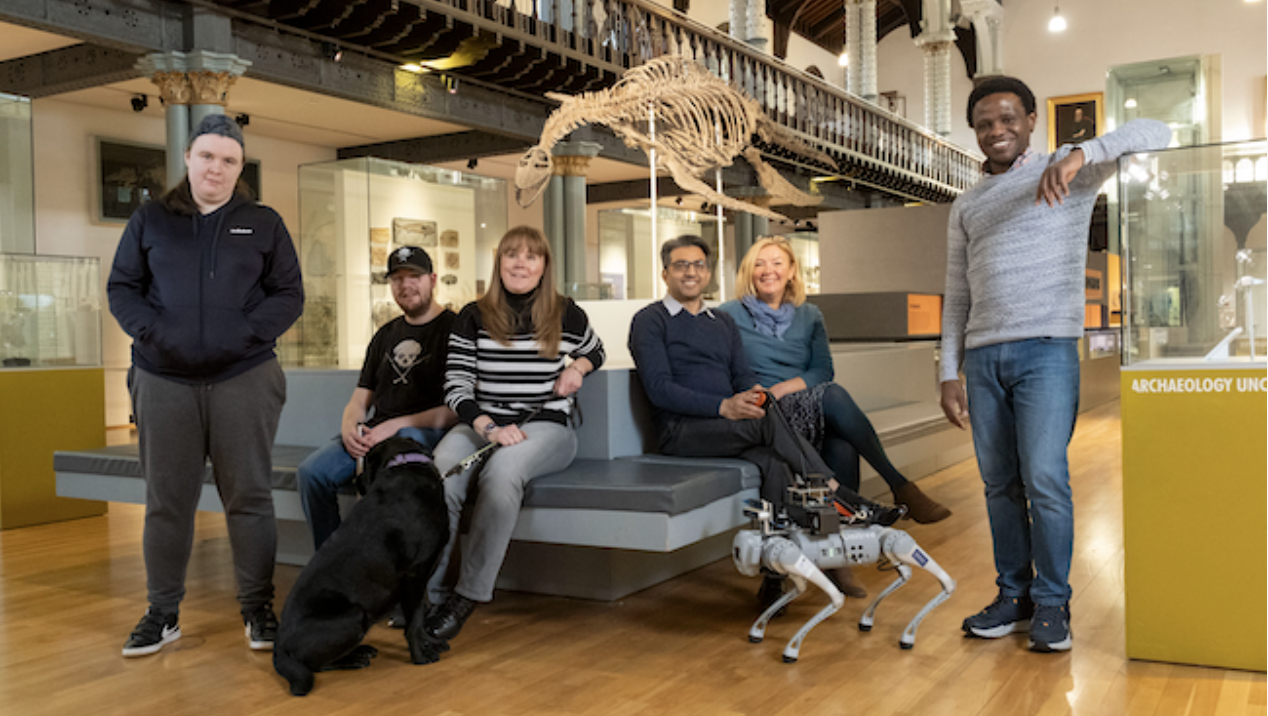The RoboGuide team at the Hunterian museum with a living guide dog and the robotic guide dog