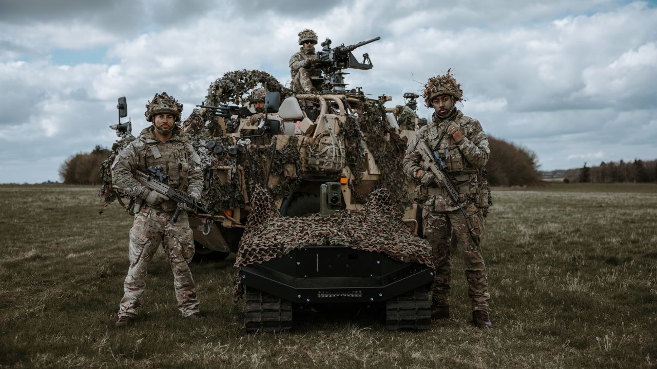 An ARX Robotics defence tech robot with four soldiers carrying guns